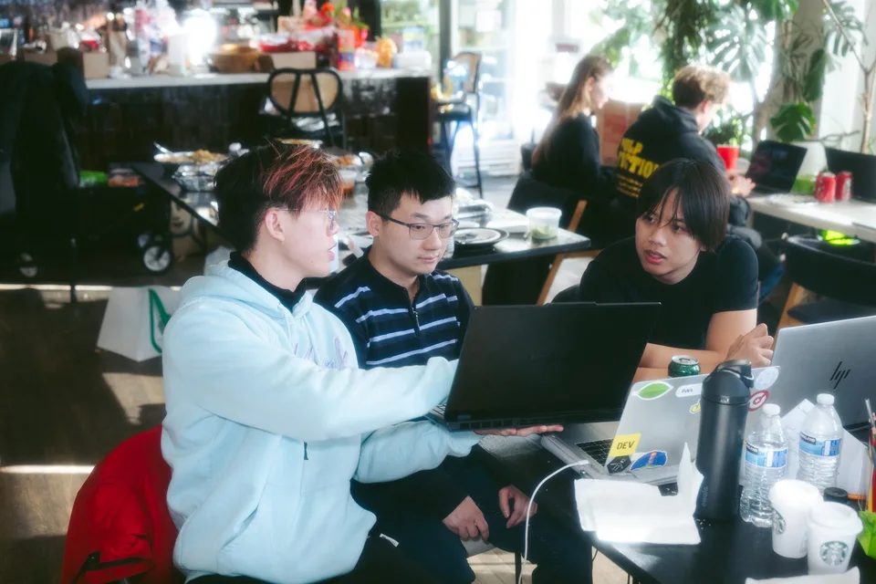 A small team collaborating around a laptop.